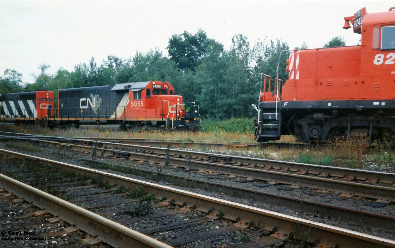 Back in September 1993 CN completed a large-scale bridge replacement west of Paris on the Dundas Subdivision. This resulted in CN rerouting trains not only on their Guelph Subdivision, but also detouring across Canadian Pacific’s Galt Subdivision for several days. In the west, the trains would begin their journey to the Galt Subdivision through the interchange track at Woodstock then onto the CP St. Thomas Subdivision for a short stretch before reaching the Galt mainline.

Here the CP Woodstock Afternoon Job with CP GP9's 8243 and 8207 take priority as they head to the Cami facility meeting CN 392 with SD40’s 5055, 5029 and 5043 as they wait to proceed eastbound on the CP St. Thomas Subdivision on the CN-CP interchange track.