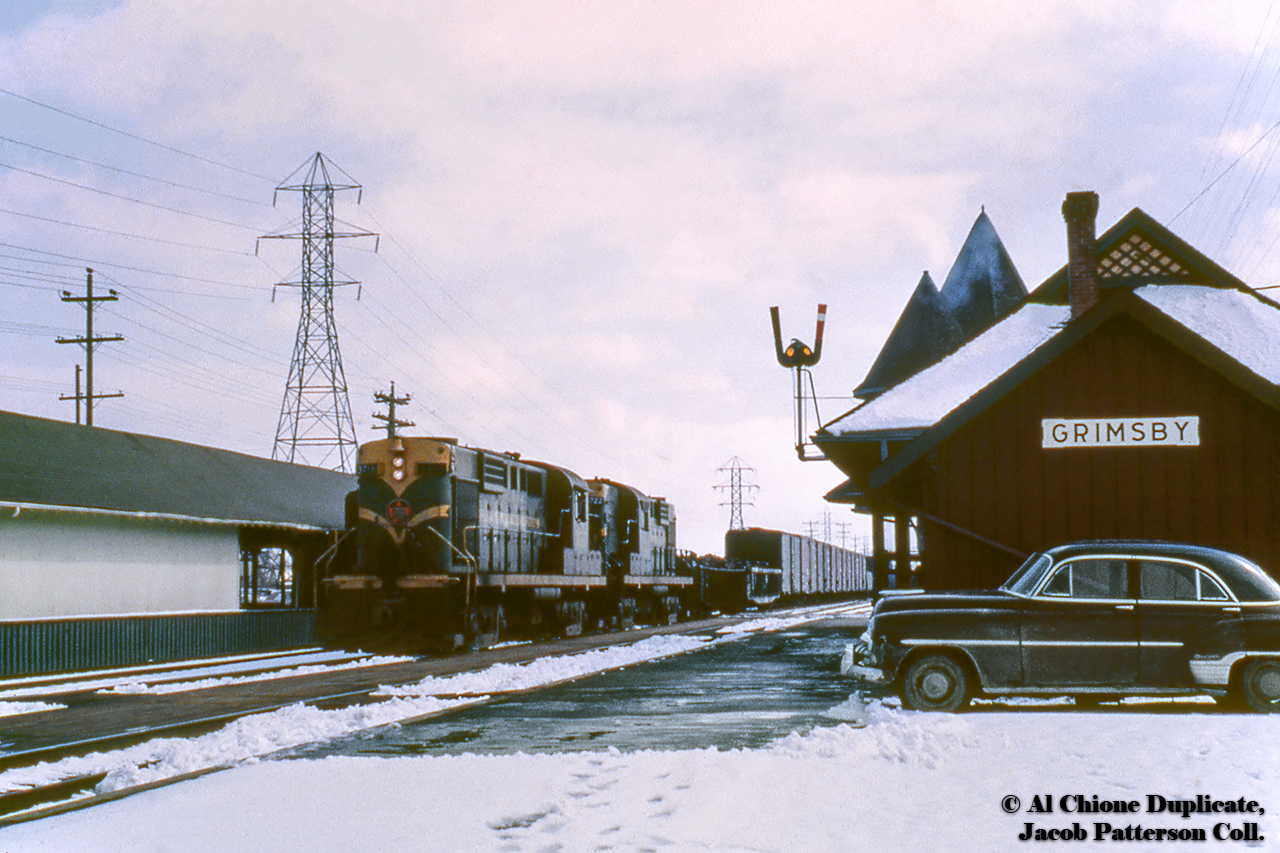 A pair of green and gold MLW RS18s lead a westbound freight through Grimsby lowing for work in front of 1902 Grand Trunk station at right, which burnt down December 31, 1994 (futher reading here), and the local freight shed/fruit platform at left.  CNR 3716 would later go to the Cape Breton & Central Nova Scotia Railway.  See the train working the freight shed track here.A 1953 track layout of Grimsby can be found hereOriginal Photographer Unknown, Al Chione Duplicate, Jacob Patterson Collection Slide.