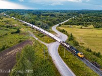 ONT 2103 and ONT 1740 head up heavy southbound tonnage on Cochrane to Englehart freight 414 as it thunders across Highway 572 just north of Ramore, Ontario. 