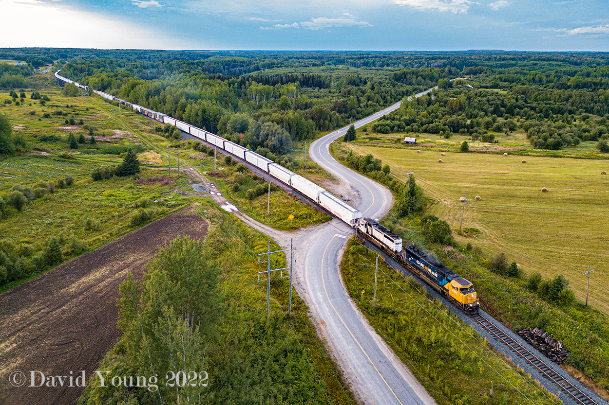 ONT 2103 and ONT 1740 head up heavy southbound tonnage on Cochrane to Englehart freight 414 as it thunders across Highway 572 just north of Ramore, Ontario.