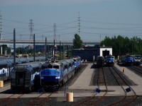 A variety of equipment is seen at EXO's maintenance centre. At far right are the first two of fourty-four cars that are built in China by the China Railway Rolling Stock Corporation (CRRC). This order has seen lengthy delays; these first two cars were delivered in February 2022, initially they were supposed to begin delivery in June 2019. In the background at left are a number of stored F59PHs.
