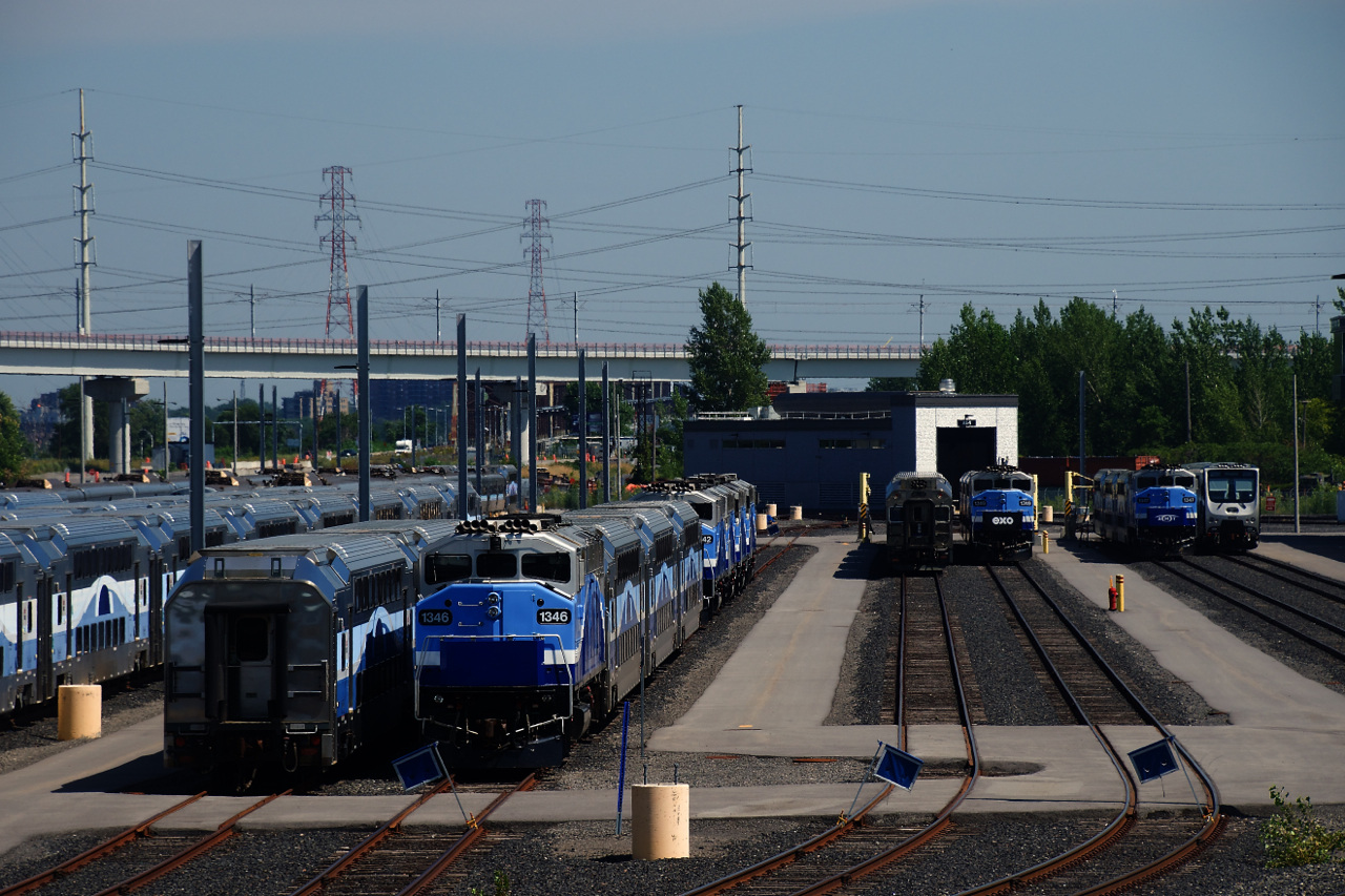 A variety of equipment is seen at EXO's maintenance centre. At far right are the first two of fourty-four cars that are built in China by the China Railway Rolling Stock Corporation (CRRC). This order has seen lengthy delays; these first two cars were delivered in February 2022, initially they were supposed to begin delivery in June 2019. In the background at left are a number of stored F59PHs.