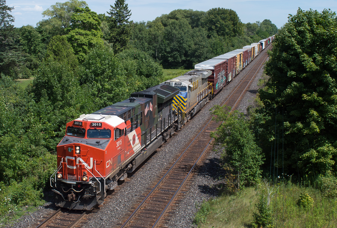 CN 397 blasts through Creditville behind CN 3015 and CN 3939.