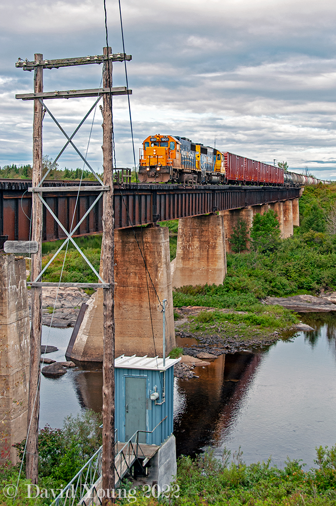 No longer legible, the old mile marker for Mile 110.3 Kapuskasing Sub still adorns the old code line pole at the edge of the Missinaibi River. Above, Ontario Northland freight 516 rolls with GP38-2 1801 leading GP40-2 2201 and a healthy string of cars. The trailing string of hoppers will be dropped at Opasatika (destined for the Agrium Mine south of Opaz Junction) while the headend eight cars will continue through to Kapuskasing where the crew will meet their counterpart and exchange traffic before returning.