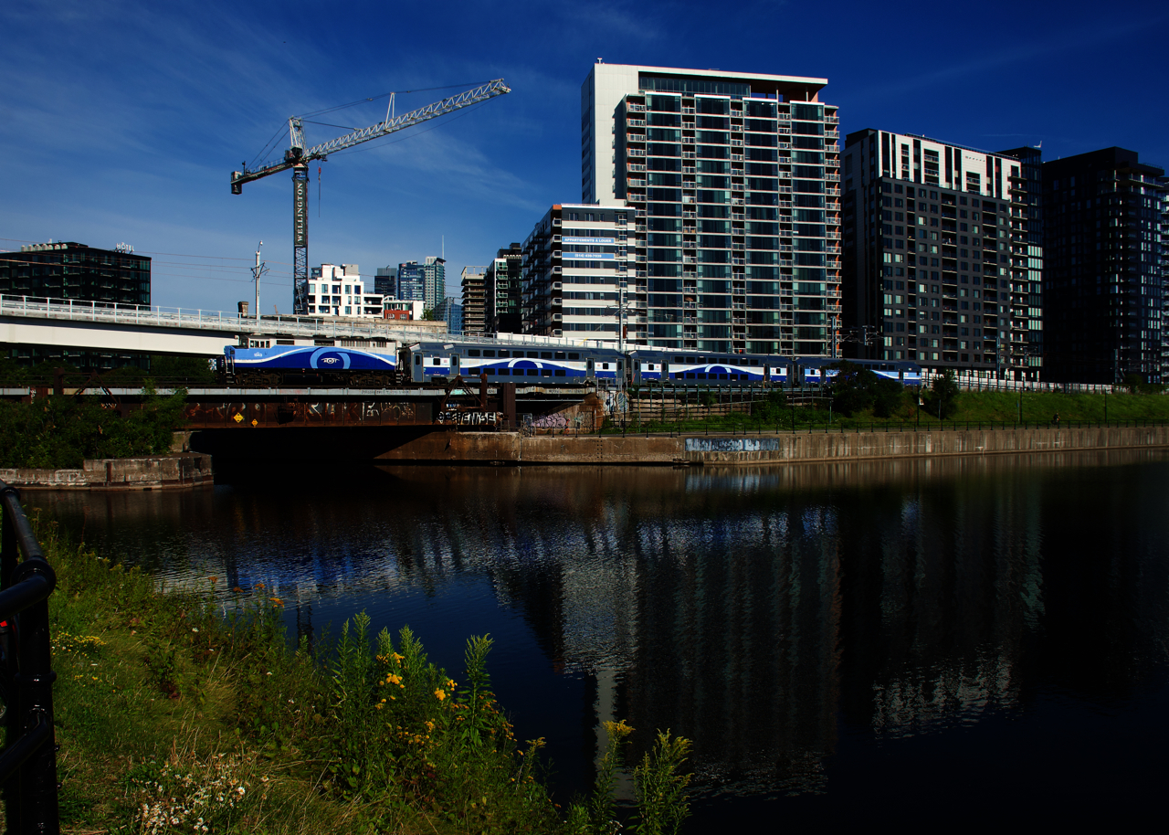 A Mascouche-line train is passing the Peel Basin with AMT 1343 and three multilevel cars. These trains used to be able to park close to Central Station on storage tracks during the middle of the day, but the REM light rail project has taken over those storage tracks and now all trains must deadhead to the EXO maintenance centre in Pointe St-Charles.