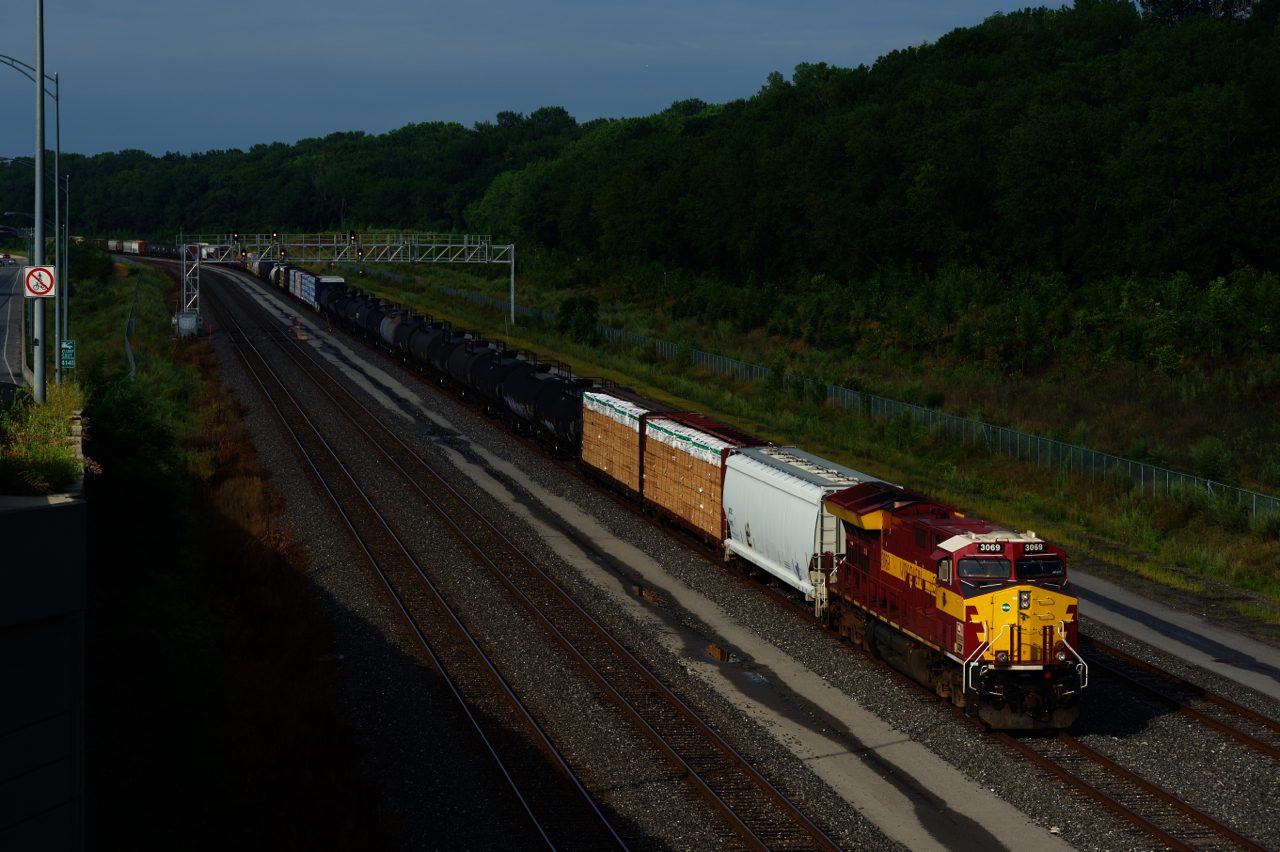 The sun is briefly out as CN 310 with the WC heritage unit leading slowly heads east after setting off cars near Turcot Ouest. A bit further ahead the train will stop until the conductor is taxied back to the head end.