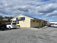 Street side view of VIA Rail's Thompson, MB station located at Mile 30.5 Thompson Sub. has VIA 693 standing at the platform with doors open to allow passengers a chance to get off and limber up a bit before continuing the journey to Churchill.
