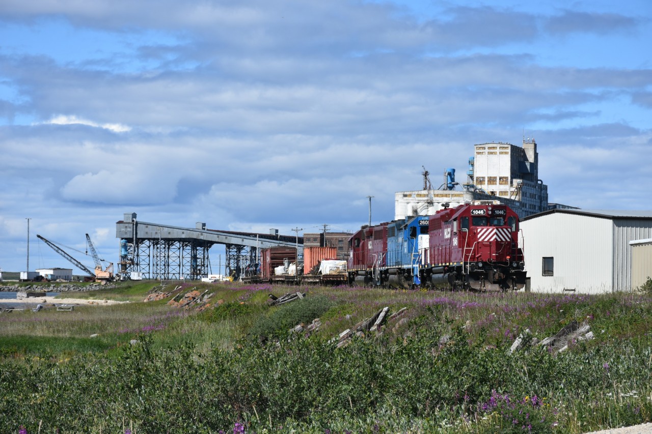 The HBR wayfreight from Gillam had arrived in Churchill earlier in the morning with this trio of locomotives and a dozen or so cars. After a crew change, the power went to work as the HBR yard engine sorting the various cars and spotting them at several different locations in the yard. HLCX 1046, the trailing unit of the three is seen here revering into the yard across from the Churchill station after having run around the loaded cars so they could spot the flat loaded with pickup trucks at an unloading ramp. The locomotive lash-up consisted of HLCX 1046, LLPX 2605, and HLCX 1041. While there hasn't been a loaded grain train over these rails leading to the massive grain storage and loading facility on Hudson Bay since 2015-2016, the very active yard crew keeps the old 85 lb. bolted steel polished with lots of carloads of construction material, vehicles, supplies, and who knows what else being marshalled along the once bustling grain dumper lead.