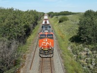 ES44AC CN 2922 heads east with a train of wrapped lumber, viewed from the Hyw 14 overbridge approaching Kinsella.