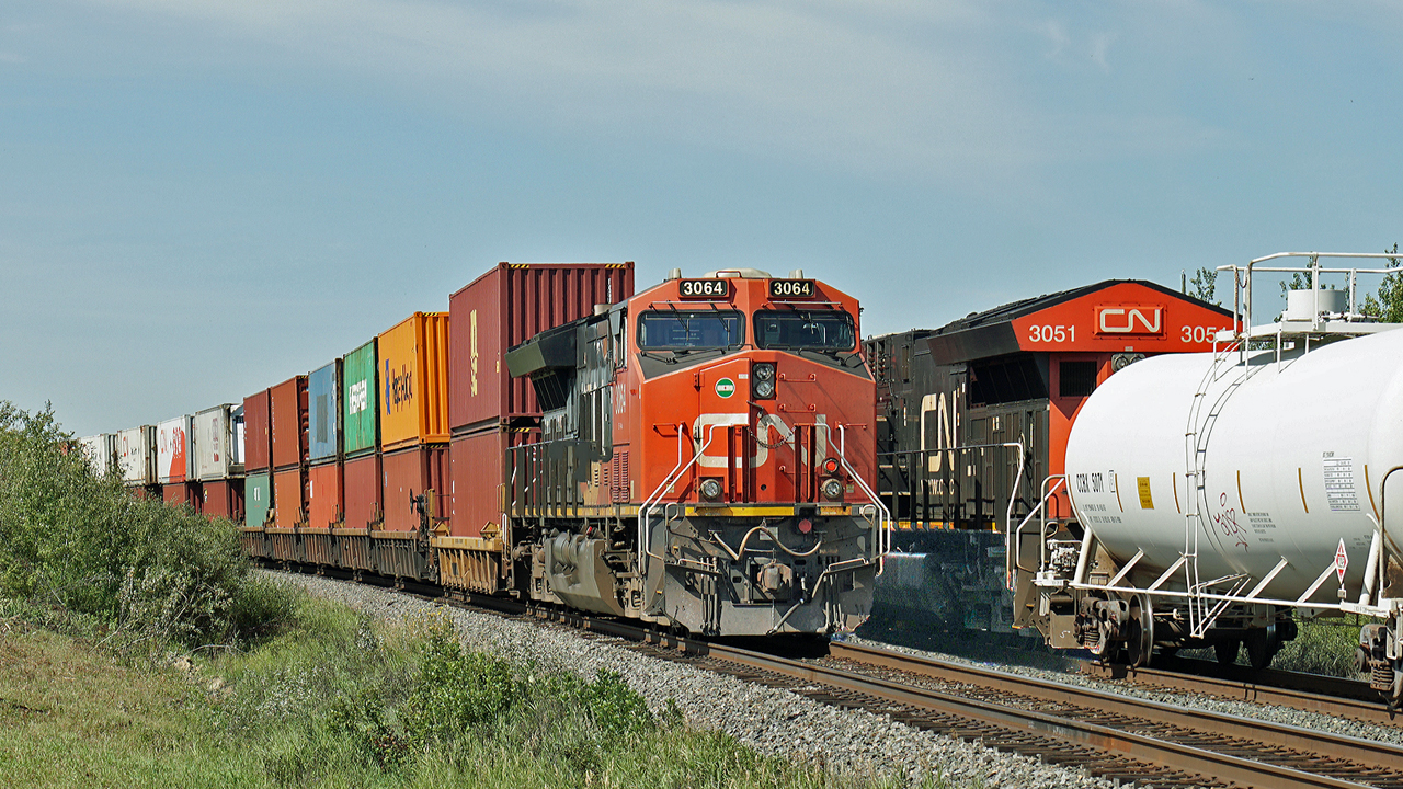 CN 3064 on a westbound intermodal passes CN 3051 mid train on it's opposing traffic