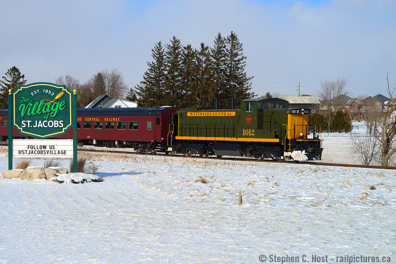The last train of the day is reversing by the Village of St. Jacobs Welcome sign with recently repainted WCR 1012 leading. This was an unexpectedly cold, windy day with tonnes of blowing snow not typical of the end of winter, but it sure made for interesting photography and very cold fingers.