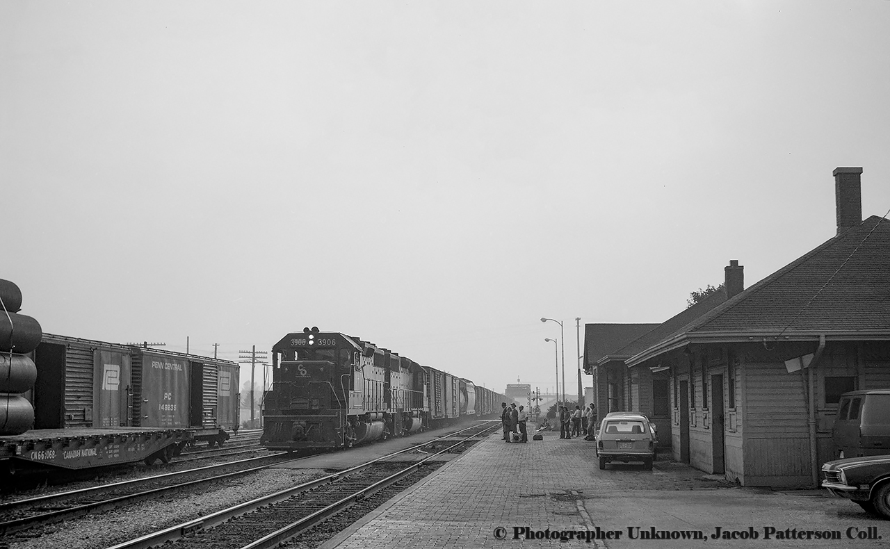 C&O GP39 3906 leads an eastbound freight across the Welland Canal and past the CASO Welland Station approaching WX Tower, the junction between the main CASO Sub, the NYC Fort Erie Branch, and the crossing with the CN Welland Sub, where Steve Host recently captured the ONR film train.  The Townline Tunnel opening in 1973 as part of the Welland Canal relocation project shifted traffic from this line, as well as CN’s Cayuga Sub, into one tunnel beneath the canal further south.  Today, everything is gone from this scene except for the south main which the C&O freight is on.  It remains as the CP Welland Industrial spur, operated by Trillium.  West of the canal, a portion of the Vesuvius spur utilizes a short stretch of former Niagara, St. Catharines & Toronto Railway right of way.  The NS&T Welland Sub ran north - south  from Substation Junction in Thorold - Port Colborne crossing the CASO mainline at their junction with the TH&B Welland Sub just beyond the bridge seen above.  TH&B trains to Niagara Falls or Fort Erie would also utilize parent company NYC's lines east from Welland to access the USA.Note at left the cars of pipes from the Page-Hersey facility just south of the tracks.  The company became a division of Stelco around 1970, later renamed Stelpipe while merging with Welland Tube during the mid 1980s.  Lakeside Steel would take over in the 2000s, and by 2012 the plant would see its final owner, Energex Tube.  Energex would be served by Trillium until closure in 2014.  More details with Arnold's linked image above.The uncommon GP39 is one of only twenty three built by EMD between 1969 - 1970.  C&O took delivery of twenty units (3900 - 3919) while the other three went to smaller roads.  This unit would become CSX 4286 by the late 1980s, eventually being rebuilt to road slug CSX 2380 in 2008.  It remains in service as of 2019.Scenes of WX Tower and area:CASO WX Tower looking west, located just north of Steve's shot, Mike P. McIlwaine photo.Looking west from the tower towards Welland station and the canal, Mike P. McIlwaine photo.West of the canal, an NYC Mikado leading a westbound TH&B freight off the CASO onto TH&B's Welland Sub to Hamilton.  Note NS&T Welland Sub diamonds.  From New York Central System Historical Society.Original Photographer Unknown, Jacob Patterson Collection Negative.