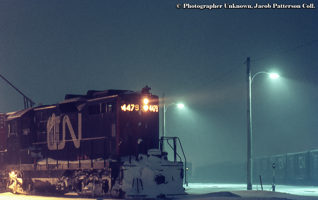 A snowy evening at Belleville finds 4479 and what looks to be an RS18 on the shop track alongside the yard.  4479 was rebuilt to CN 7002, retired in 2000, and sold to Pioneer Rail Corporation in 2003.Original Photographer Unknown, Jacob Patterson Collection Slide.