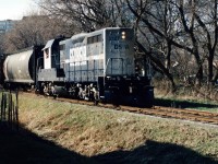 During spring 1999 and less than one year after the Goderich-Exeter Railway (GEXR) had acquired the Guelph Subdivision and related spurs, units formally assigned to the Goderich Subdivision could be seen operating on the fairly still recently absorbed trackage.  
<br>
On April 8, 1999 word went out that Georgia Southwestern (GSWR) GP7u 2127 was assigned to train 582 and went north to Elmira during the afternoon on the Waterloo Spur. The former ATSF unit had certainly attracted a fair amount of attention and returned to Kitchener later in the early evening from Elmira.
<Br>
Here GEXR 582 with GSWR 2127 is pictured slowly approaching the John Street crossing on the Waterloo Spur as it returns to Kitchener with three hoppers lifted from Nutrite Feeds in Elmira. 
