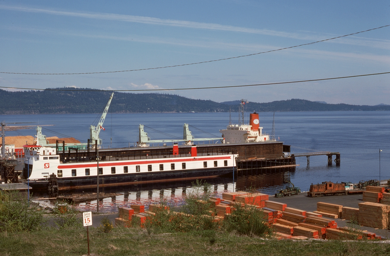 On the east coast of Vancouver Island at the BC Forest Products mills at Crofton, the primary railway connection to the mainland was provided by rail ferries, here showing as SEASPAN DORIS (formerly DORIS YORKE of F. M. YORKE and Sons) and about to be switched by Whitcomb number 9 of Stuart Channel Transportation shown lurking at the lower right on Friday 1975-05-09.

CP’s E&N had a direct connection to Crofton, known to CP as Crofthill, from a junction at Osborn Bay, but in later years it was used only when various marine difficulties made the rail ferry option unavailable.
