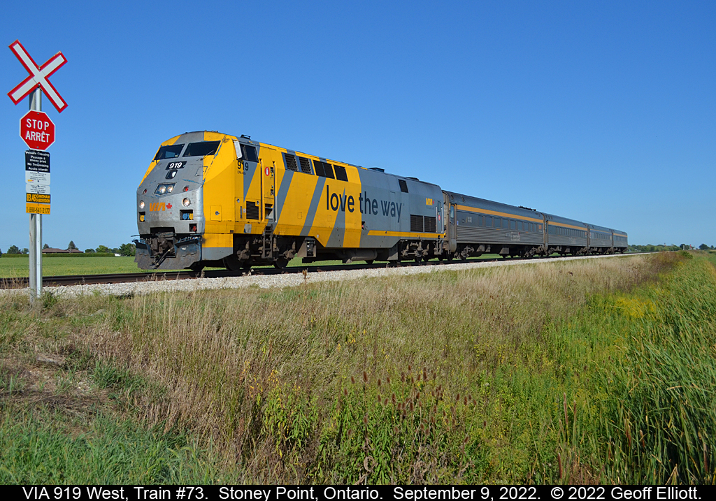 VIA #919 is 'Loving the Way' of a 1/2 hour late running train #73 as it hits the farm crossing at MP 83.46 of the VIA Chatham Sub on a day with nothing but blue skies for a background.