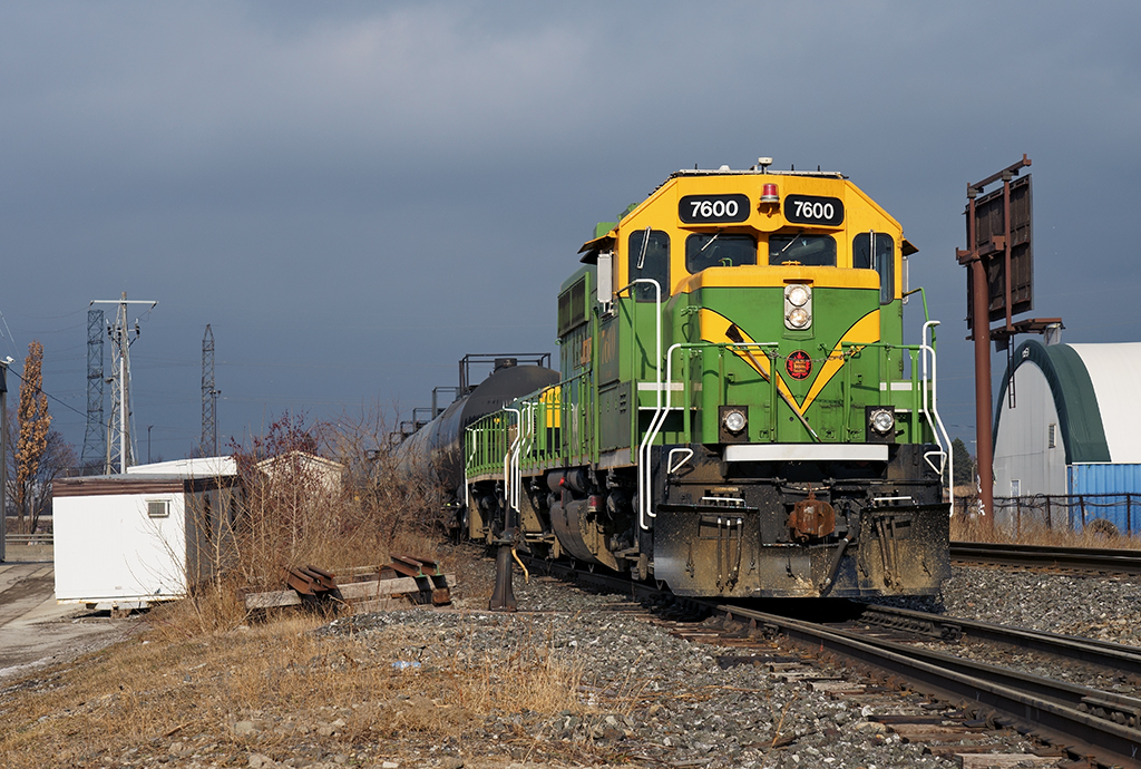 A heritage yard set is in the middle of switching out Imperial Oil along Metrolinx's Newmarket Subdivision, the sunlight from a brief sucker hole illuminates how much grime has accumulated on the GP40-3 during it's first year and a half at Mac Yard in yard and industrial switching.