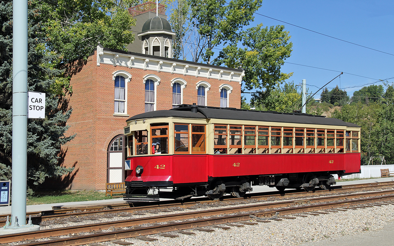 Edmonton Radial Railway Society's car #42 draws up to the car stop outside the 1893 Fire Hall at Fort Edmonton Park. When built in 1893 the fire hall sat at 98 Street and 101 Avenue and served as town office, police station and fire hall.  The street car was built in 1912 by the St. Louis Car Company for the City of Edmonton and was in service until the end of street car operations in 1951.  After restoration by ERR it was put into service in 1984 at the Park where it has been the reliable workhorse ever since.