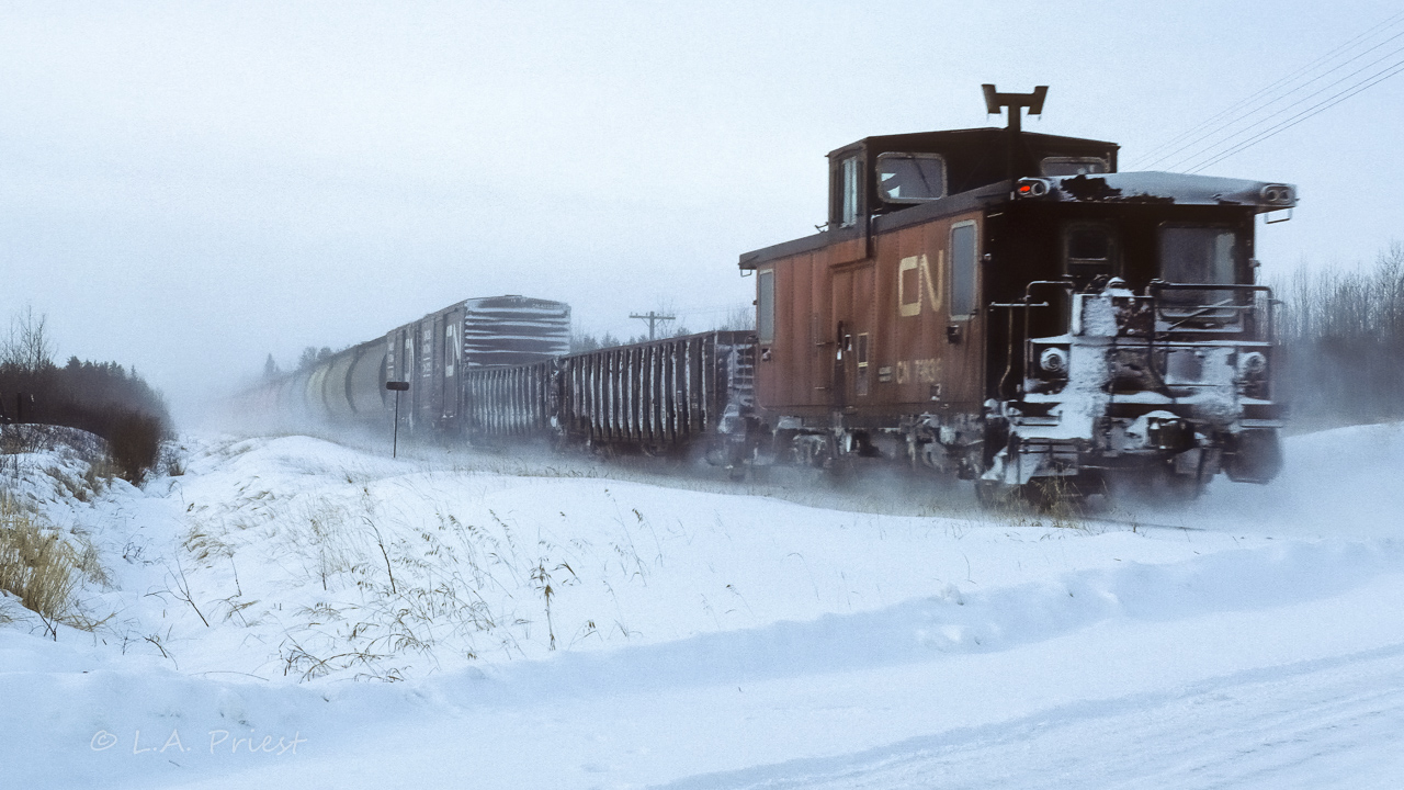 How nice it was to have a toasty caboose when working in weather such as this. The 5510, 4347 and 5506 have 40 loads of grain and some empty gons headed back to Calder yard. Photo taken at mile 23.8 at 10:40, shot at f11, 1/125 sec, with 50mm.