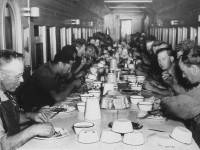 My recent postings of dining car interiors from trips on VIA 693 & 692 (Winnipeg-Churchill-Winnipeg), and VIA 1 & 2 The Canadian (Toronto-Vancouver-Toronto) prompted a reminder from my brother Terry about the dining cars we ate in while working summer extra gang jobs in 1969, 70 & 71 on CN's Great Lakes Region. This photo I retrieved from the CN archives on the 2nd floor at H.Q. when I worked there in the early 1980's is a great example of how upwards of 100+ men could be well fed three times a day in an old heavyweight passenger car converted to a dining room. Food was prepared in bulk and brought in from the kitchen by the cookee and placed at intervals the length of the table. In the morning, plates piled high with fried eggs, others with bacon and/or sausage, hundreds of slices of toast, buckets of oatmeal, pitchers of powdered milk, and always bowls of oranges & apples. I remember the General Foreman and his foreman always sitting at the end of the table closest to the kitchen car (served first), and how there was no talking (other than asking for something to be passed down the table), no smoking, and no loitering. When you were done eating, you got up, took your dishes to the end of the car, scraped the leftovers into a garbage can, put the dirty dishes and silverware in a bin, and left. Great days working and eating on the extra gangs, and now 50+ years later great days travelling and eating on VIA trains all over Canada. :-) (location Province chosen is a guess)