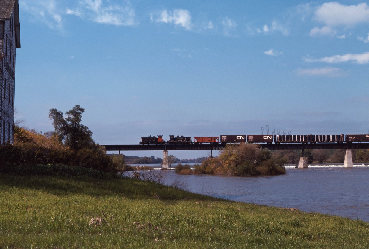 CN train 535 ("the South" roadswitcher) crosses the Grand River in Caledonia behind a pair of SW1200Rs units, the usual power in the 1970s. This train would travel up Hamilton's Ferguson Avenue twice per day until the 1980s when service was re-routed through Brantford.