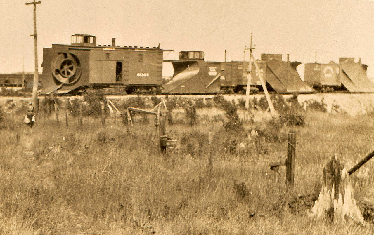 Canadian Northern early rotary snowplow 61303 enjoys the summer along with other snow equipment. Location and date are a total guess, but Capreol, Ontario is a reasonable guess based on location of water tank (cropped out of image) and yard tracks. The 61303 was scheduled to be renumbered CN 55070 in the 1920 master renumbering plan and may or may not have actually been renumbered. Apparently, there was also a 61301 of similar design. Any additional information would be appreciated.