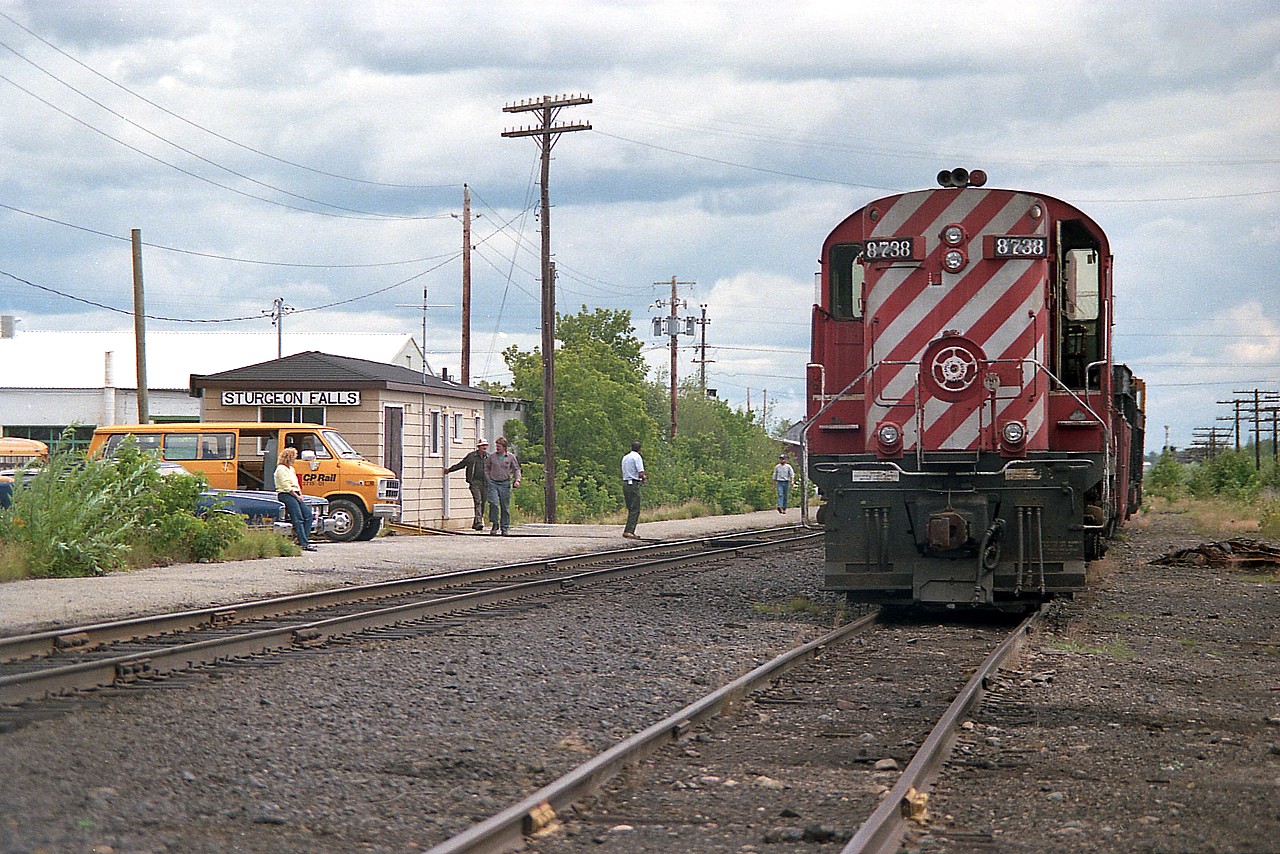 Unfortunately for me the first time I rolled into Sturgeon with the intent of shooting the town train station, it was about 6 years demolished. I think it came down in 1973. Instead, in its former location at the foot of Main St in town, we get this little structure, one of many of its type in the North. The section boys made good use of it, and as well it had a waiting room for those hardy enough to wait out the VIA Canadian here. I say hardy because when I was there the phone didn't work and there was no way of knowing where the train was. And it was almost always late.
In this scene the work train with CP 8738 is on the siding while the boys went for lunch. A few others showed so I guess we can call this "a working lunch". It is time to go back to work after having their fill of TIMs coffee, the outlet just out of sight on the right.
The sidekick of the day watches the proceedings from the car.
   Time was winding down for the MLW RS-18 8738. By 1989 it was rebuilt to CP 1850 and eventually ended up on the WNYP.