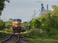 A well worn CSX dash 9W leads CN 327 to the border at Godmanchester, Quebec earlier in the summer. Passing mile 200 of the Montreal Sub and the switch for the wye that has been severed.