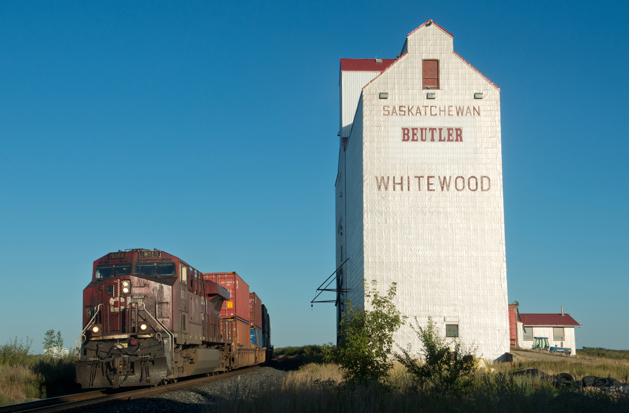 An extra grungy coal motor leads hotshot #119 past the one remaining elevator at Whitewood Saskatchewan.