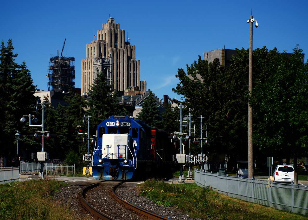 Ex-GMTX CN 4904 & CN 4135 are leaving the Port of Montreal with an even 50 cars as they pass one of the many crossings in this area.