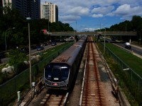 A line 1 subway train is approaching Eglinton West Station.