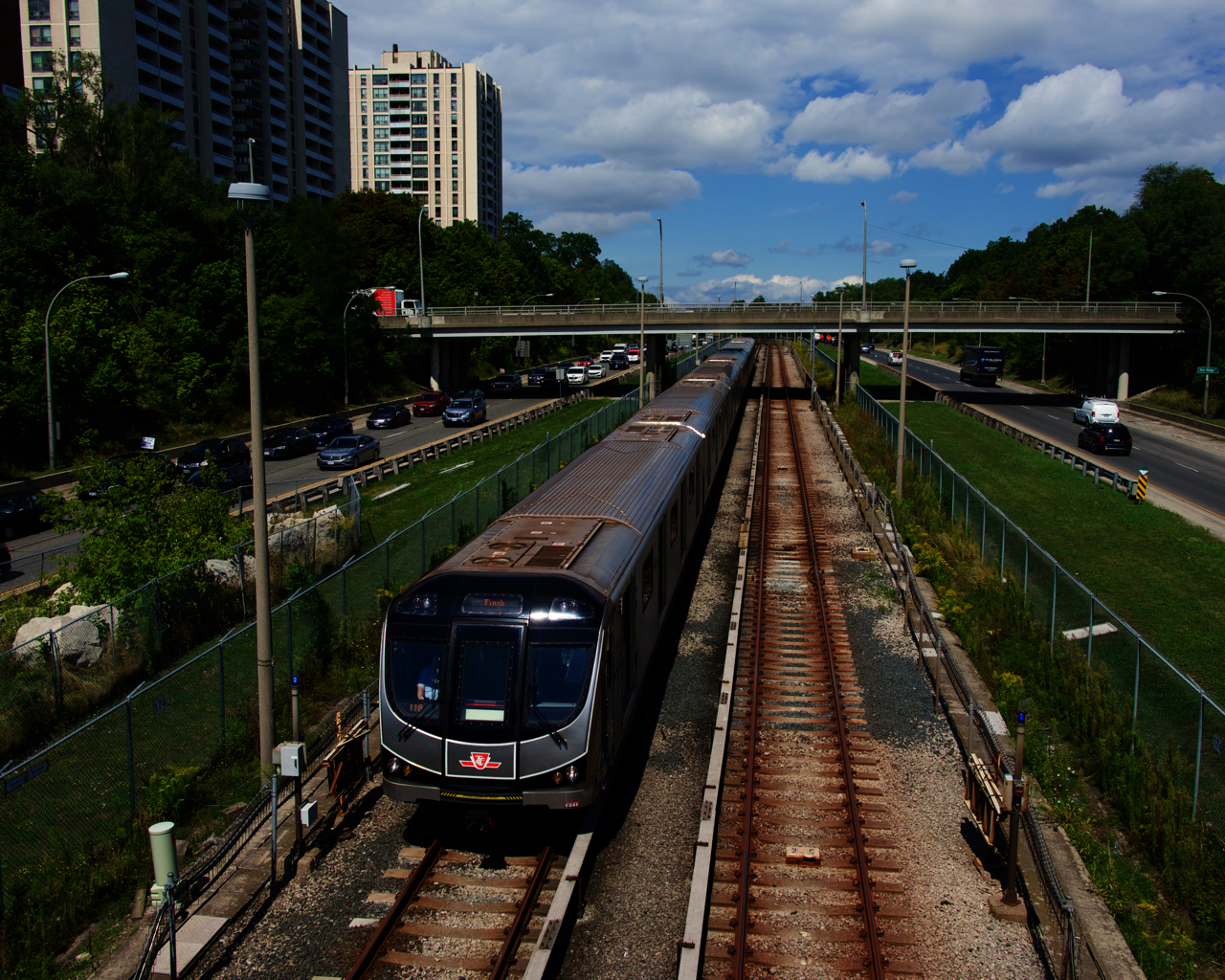 A line 1 subway train is approaching Eglinton West Station.