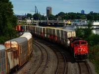 Halifax-Chicago CN 123 is rounding a curve with stacks up front and racks further back.