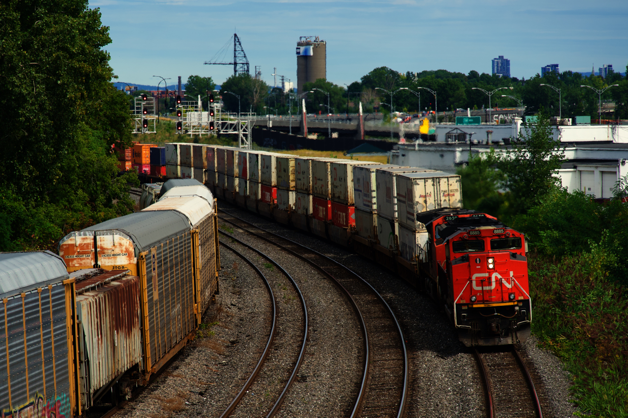 Halifax-Chicago CN 123 is rounding a curve with stacks up front and racks further back.