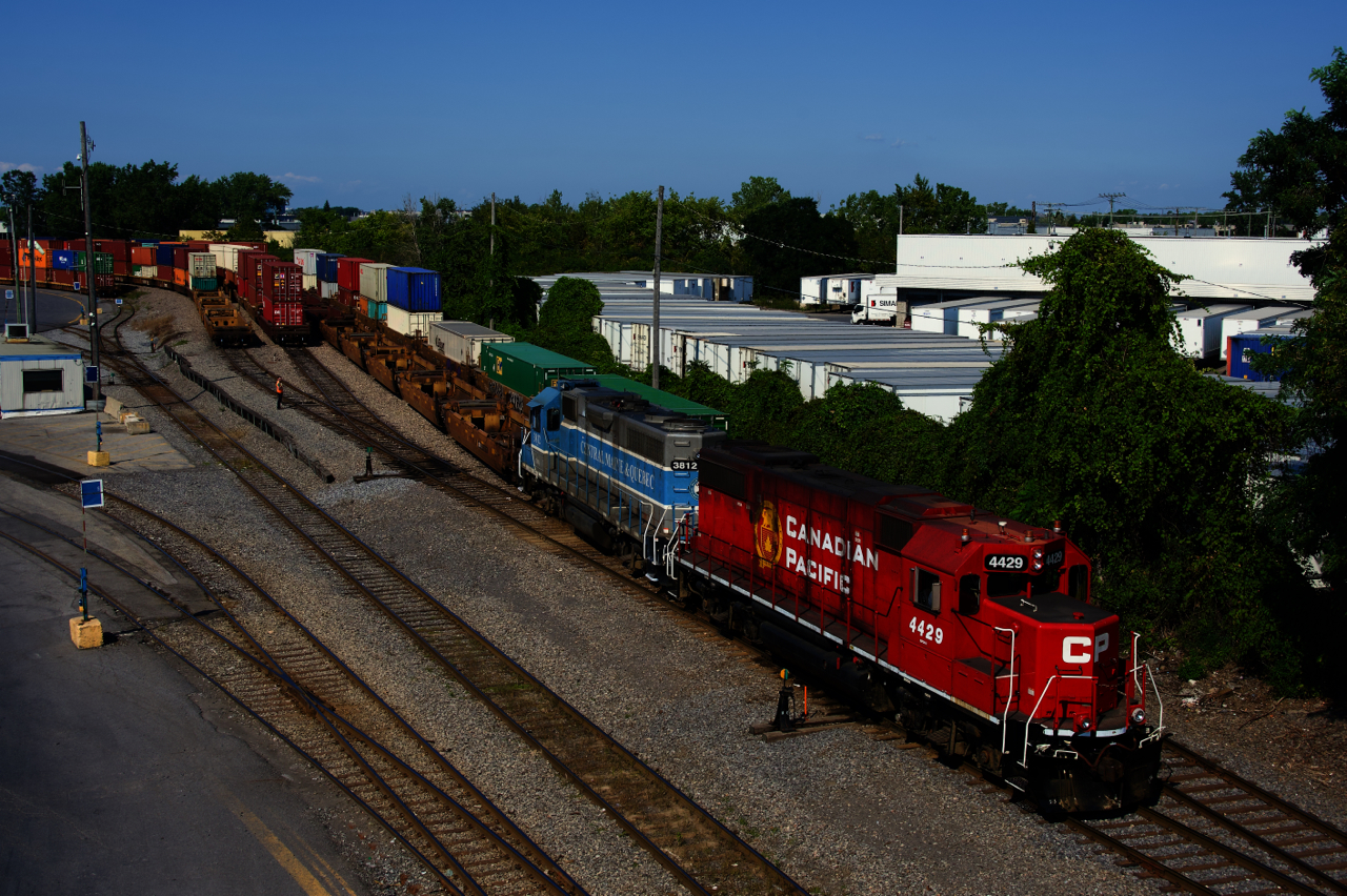 An extra with a nice lashup of CP 4429 & CMQ 3812 is shoving a long string of well cars into the Lachine IMS Yard.