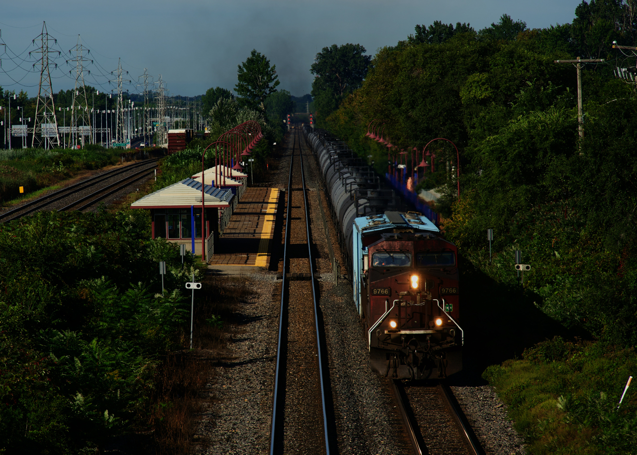 A filthy AC4400CW leads ethanol train CP 528 through Cedar Park Station. Barely visible in the distance at top left is the tail end of CN 369.