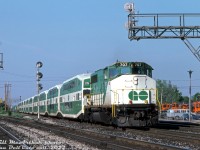 GO Transit GP40-2W 707 leads a 10-car train of bilevel commuter cars through Burlington West bound for Hamilton, after making its station stop at the nearby Burlington GO station. Cab car 205 trails the lead unit, and a 900-series APCU brings up the rear. The two tracks on the left are for CN's Halton Sub mainlines, branching off from the Oakville Sub here.
<br><br>
The <a href=http://www.railpictures.ca/?attachment_id=34977
><b>old station</b></a> (hidden by the train) was still in use by VIA at the time, but VIA would soon move its operations to the nearby GO station in another two years. Orange CN maintenance of way equipment sits stored on the Burlington West back tracks.
<br><br>
<i>Bill McArthur photo, Dan Dell'Unto collection slide.</i>