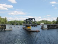 The Island Queen is navigating the South Channel between Rose Point and Parry Island and has just passed the former Canadian National Railways swing bridge at Mile 4.9 Depot Harbor Subdivision. The bridge commonly known as the "Rose Point Swing Bridge" was built by the Ottawa, Arnpior and Parry Sound Railway in 1912, the bridge no longer carries rail traffic. Known officially as the Wasauksing Swing Bridge the bridge is owned by the Canadian Government and provides the only road access to Parry Island. Studies to replace the present structure have been underway for several years.