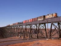 Now mile 109.4 on CP’s Taber sub. (extended west 8.0 miles onto the former Crowsnest sub. to the new Lethbridge Yard from old Lethbridge), the long Oldman River bridge also passes over the 1 Ave. SW exit from highway 3, and on Monday 1974-10-14 it carried an eastbound wayfreight with ex Quebec North Shore & Labrador GP9 PNC 122 for power towards the yard in town.

<p>The construction-era (1897-1898) line west from Lethbridge avoided the immense bridge by swinging considerably south of today’s line to cross the Saint Mary River on a substantial wooden trestle then the Belly River on another to avoid the Oldman River, then trending northwest to join today’s line at Fort Macleod.  A great map showing that is at <a href=“https://railways.library.ualberta.ca/Maps-7-4-2”> Atlas of Alberta Railways Maps </a>.