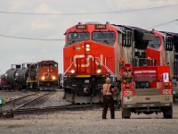 CN's shortline hub in Regina bustles with activity as A423's conductor walks over for a quick chat with a foreman after manning a switch to re-couple his power with his train. 4797 is paired with 7265 behind it working the yard before they send a cut of transfer cars to CP.