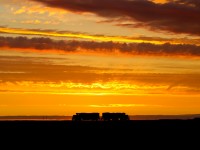An often missed opportunity by many in their sleep is the share of good sunrises in the land of living skies. Here a pair of GP38s on the midnight yard job in Regina become a de-facto "locomotive henge" as sun beams diverge from the middle of the pairing whilst the patient crew waits for their next assignment.