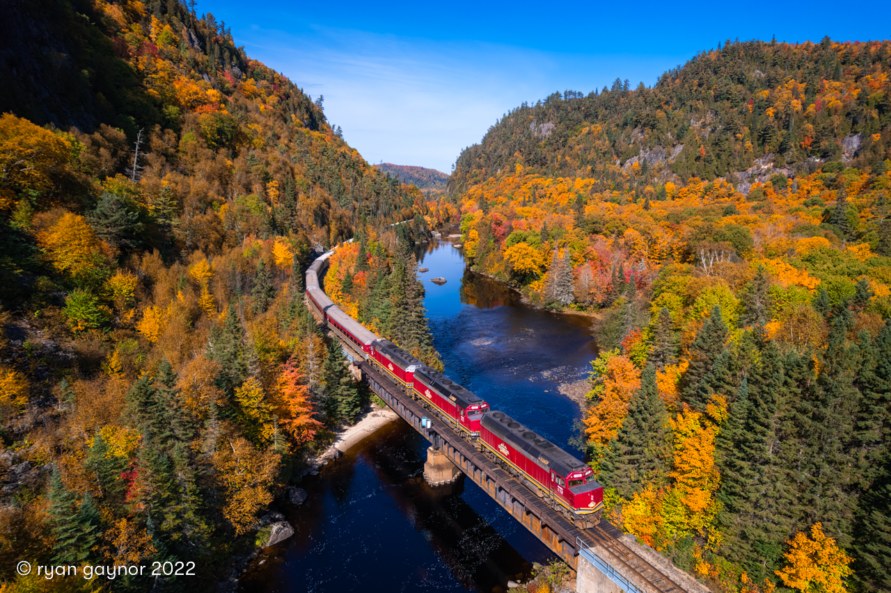 Emerging from the Canyon under spectacular autumn skies, a trio of EMD F40PHR locomotives hustle Watco's sold-out Agawa Canyon Tour Train over the Mile 112 trestle on the "new ACR". In February 2022, Watco purchased the old Algoma Central line from Canadian National, tastefully naming it the Agawa Canyon Railroad and resuming tour train operations for the world to enjoy. On this day, 846 passengers from around the globe were able to take in the autumnal splendour of Agawa Canyon; the crown jewel of Algoma Country.