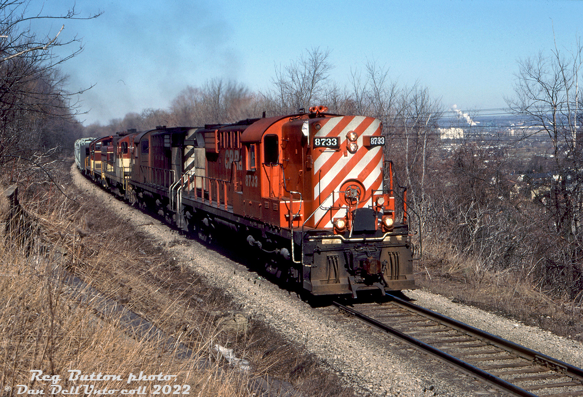 In the 1980's, the TH&B's motive power situation was getting dire due to reliability issues with its small fleet of aging first generation diesels. Parent CP Rail was often lending 4-axle power including RS18, C424, and leased B&O GP38 units. Here, CP RS18's 8733 and 8791 lead TH&B GP9 401, NW2 51 and SW9 57 in a mix of 251 and 567 noise as they climb "the mountain" out of Hamilton with a heavy rock train, seen here at Dewitt Road on the ascent to Vinemount. The two switchers were some of the only ones in the fleet equipped with MU, so were often seen working mainline trains with TH&B's Geeps and leased CP power. In a few more years, motive power officials with CP would retire the TH&B's fleet of switchers, and have the Geeps (most ended up stored out of service at John Street upon major failure) rebuilt as fresh CP 1680-series GP7u and GP9u yard units.

Reg Button photo, Dan Dell'Unto collection slide.