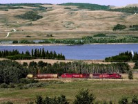 Grain empties train 356 passes the Ghost Reservoir on the Bow River near the former Cheneka siding just east of Morley on the Stony 1st nation reserve