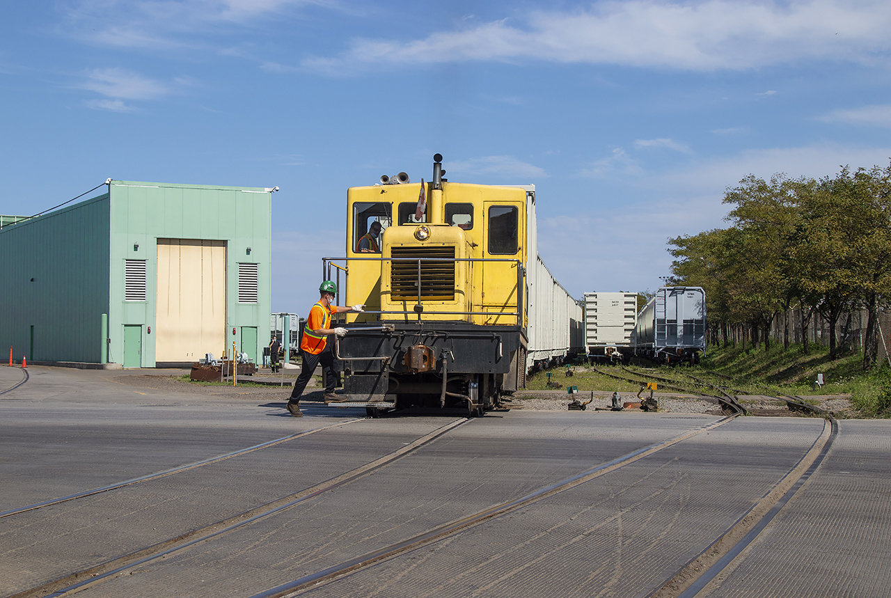 One of National Steel Car's GE critters moves a cut of gons around the plant.  Not many units remain utilizing footboards for crew members.