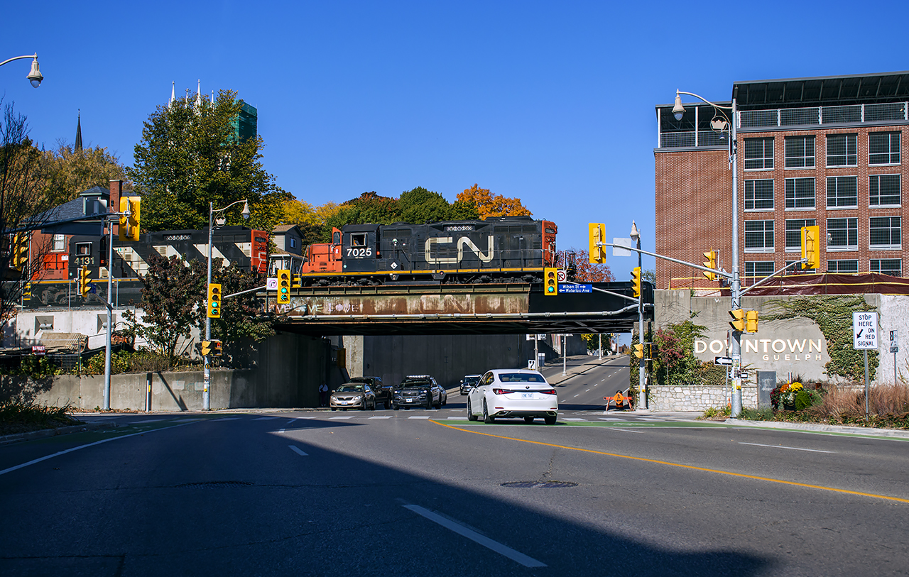 CN L540 heads east through the changing skyline of downtown Guelph with traffic for Canwel at Acton.  Up until recently, only the north track was in use through here, with the south seeing it's last train around 2007 due to a broken rail.  The majority of south track would be lifted during 2014.  With plans for Metrolinx to increase service on their Kitchener Line to 2-way, all day frequency, the south track is to be reinstalled, requiring restoration work of this bridge (Norfolk Street, built 1967) and Wilson Street (off to right, built 1902, full replacement).  With the south spans repaired/replaced, current rail traffic has shifted south for the north spans to be worked on.  Other work includes rebuilding/strengthening of the retaining walls nearby, a new south platform at the station, and more in the future.