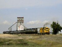 Great Sandhills eastbound from Home terminal of Leader to Swift Current with leased NREX power still with Santa Fe Colours passes the wooden elevator at Prelate on The former CP secondary line from Swift Current to Bassano. The tank cars are a combo of LPG loads from the Empress gas Plant near Burstall and the empties out of storage