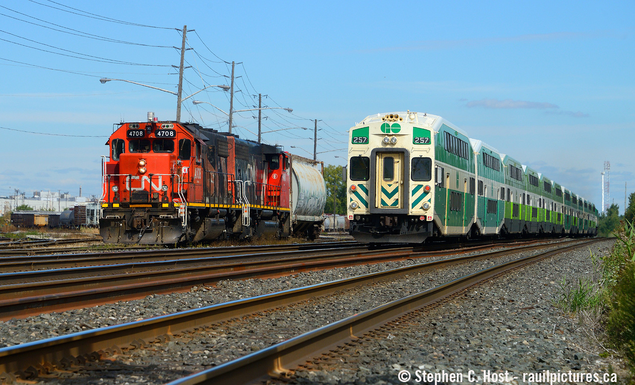 A GO transit eastbound blasts by L554 with a single sugar hopper in tow from Lantic at Mimico, about to lift their cars in the yard and head to Aldershot.