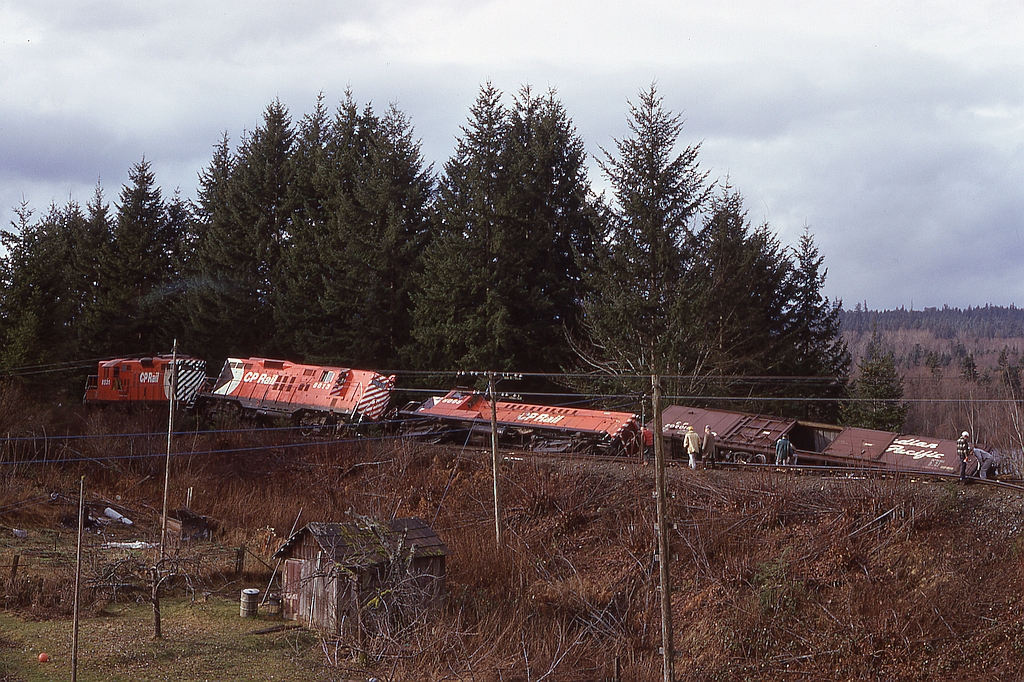 A broken rail caused early-morning southbound freight No. 52 to derail just south of South Wellington on Vancouver Island on Wednesday 1974-02-20.  Lead GP9 8531 had only its rear truck derailed, and the crew members were fine, but GP9 8613 was well and truly off and Baldwin 8005 went over so far it’s internals were damaged and that was its last run.

This location is just one and a half miles south of the head-on collision on 1973-06-12 which ended the working lives of Baldwins 8006, 8007, 8008 and 8011.