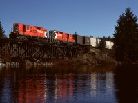 While broadside telephoto shots from 400 metres away across the lake were okay, they inspired my purchase of a small inflatable boat to capture closer views of the mileage 79.9 trestle bridge on the east side of Green Lake north of Wellington on Vancouver Island.  One result from Wednesday 1981-03-18 was train No. 71 from Wellcox yard in Nanaimo heading to Port Alberni behind GP9s 8646 and 8657 caught at 1330 PST.